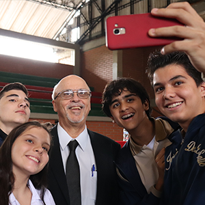 Brother Robert (Bob) Schieler taking a selfie with four students.